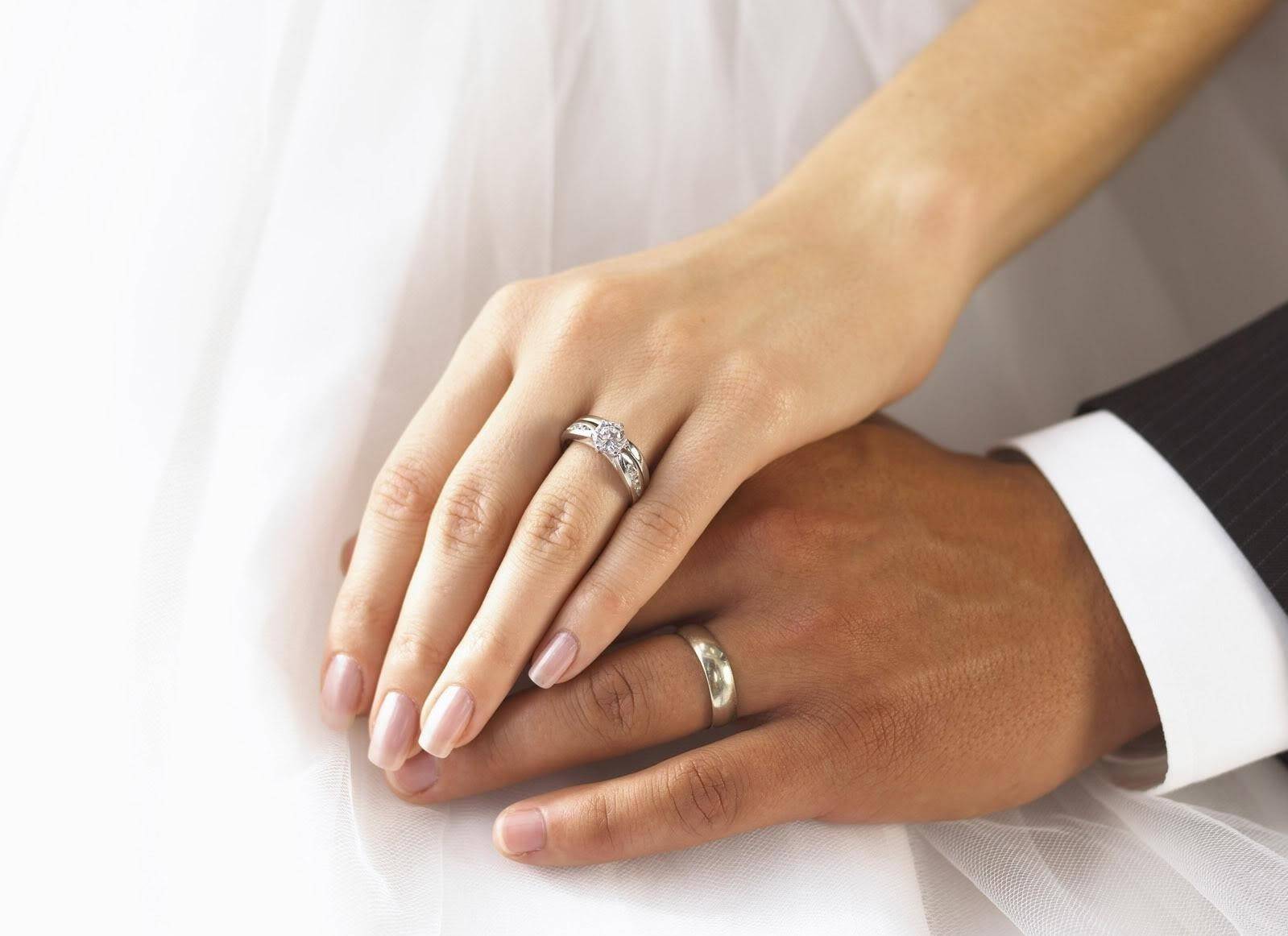 Обручальные кольца на руках у пары